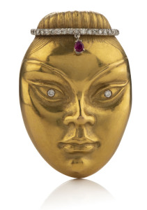 A handcrafted 18ct yellow gold face brooch encrusted with approximately .52ct of diamonds and a .25ct ruby, 6cm high, 40.6 grams