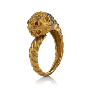 An 18ct yellow gold lion design ring with white gold and diamond collar and ruby eyes, stamped "Ilias Lalaounis 750"