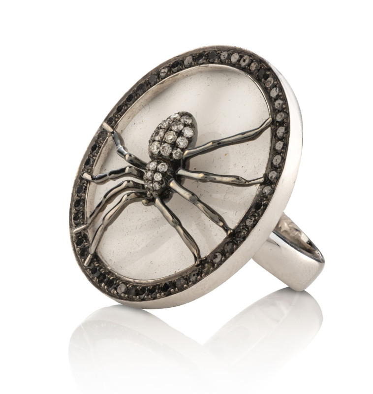 An unusual 18ct white gold and diamond dress ring in the form of a spider, with polished French glass backing and titanium border mounted with brilliant cut diamonds