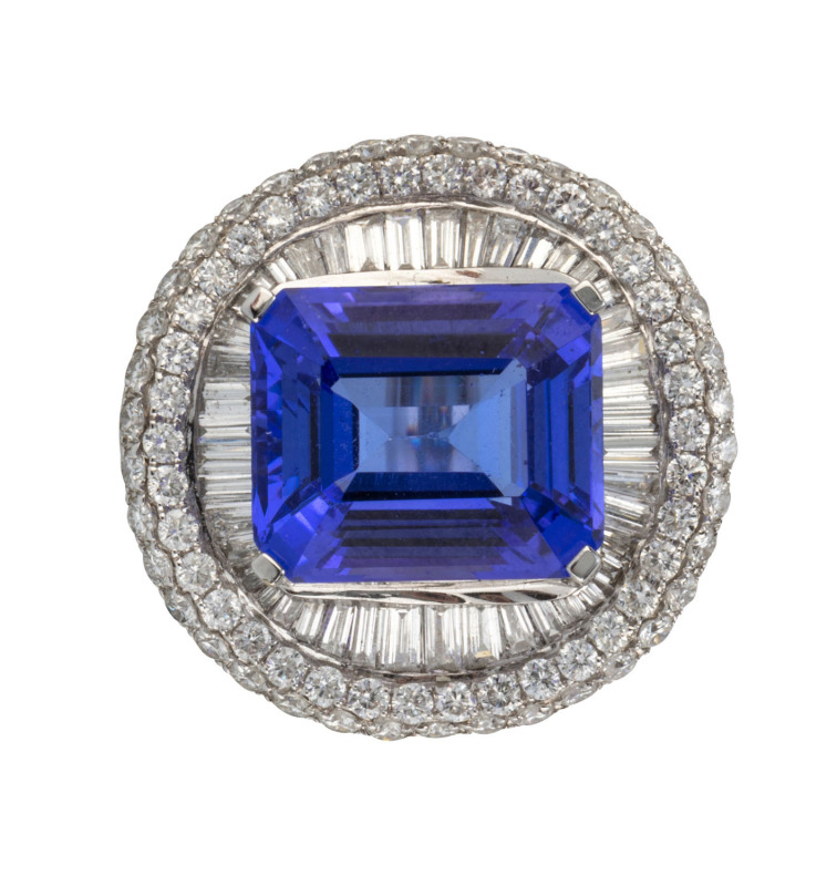 An 18ct white gold cluster dress ring set with 9.6ct emerald cut tanzanite surrounded by 44 channel set tapered baguette diamonds (clarity VS, colour G), additionally surrounded by 76 brilliant cut diamonds