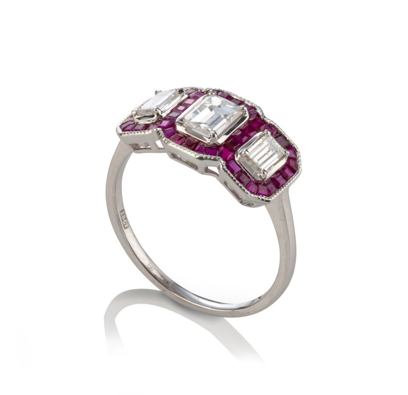 An 18ct white gold ladies dress ring featuting three emerald cut diamonds surrounded by French cut rubies