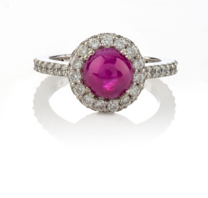 An 18ct white gold ladies dress ring set with cabochon ruby surrounded by brilliant cut diamonds on the bezel and shank, [Diamond & Gemstone Bourse (Aust.) Insurance Valuation $5,950],