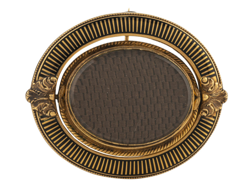 A Georgian mourning brooch, gold and enamel with revolving woven hair panel, 4.2cm high