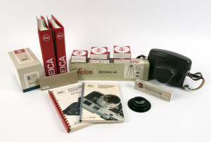 LEITZ: Accessories for Leica comprising BOOWU-M close-up camera copy stand in box; OZXVO Visoflex cable release in box; 16557Q Leica M bellows in box; 14051 & 14103 caps in boxes; 13009 filter in box; 14098 & 14099 adaptor rings in boxes; 16469 extension ring in box; plus a Leica M ERC in brown leather, 14126E film leader trimming plate and 16558Z for lens mount; the last 3 unboxed. (12 items).