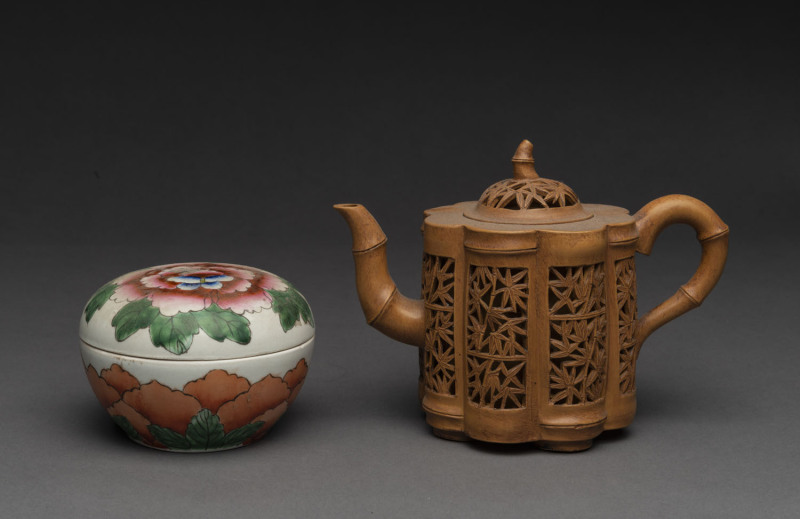 A Chinese reticulated pottery teapot together with a famille rose porcelain lidded box, 19th/20th century, the teapot 14cm high
