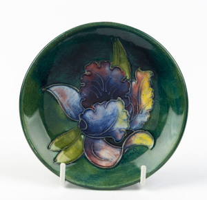 MOORCROFT "Orchid" pattern dish on green ground, stamped "Moorcroft, Made In England", and with paper label "By Appointment, W. Moorcroft, Potters To Late Queen Mary", ​12cm diameter