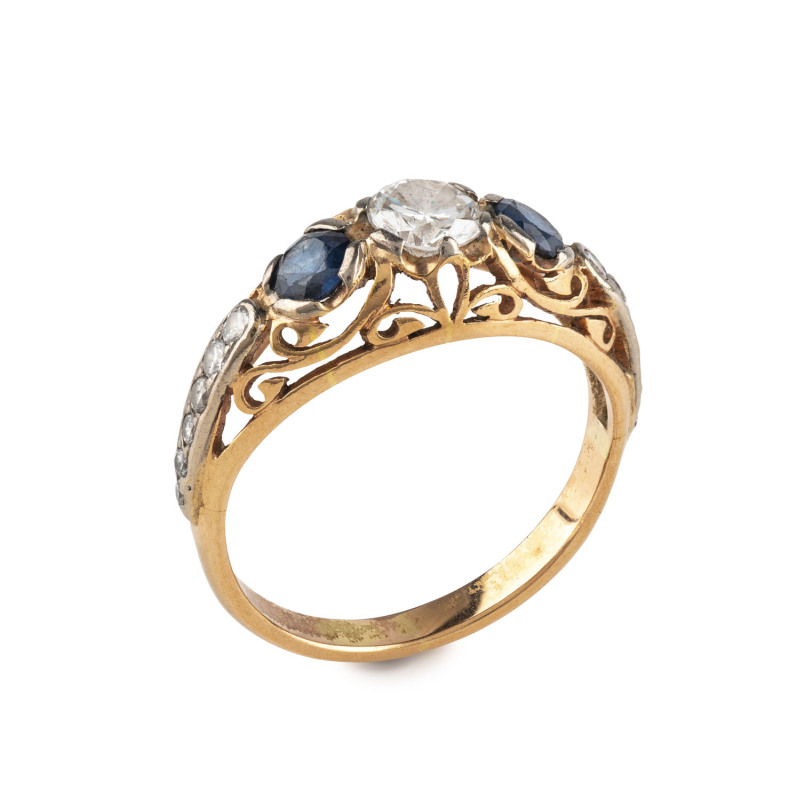An antique gold ring, set with an impressive central diamond approximately 0.50ct flanked by two Australian blue sapphires with a further row of six graduated diamonds on each shoulder