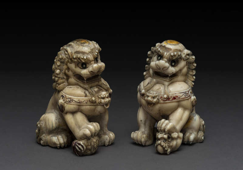 A pair of Chinese Dogs of Fo, carved ivory with remains of parcel gilding and red enamel, Chien Lung Period (1736-1795), 10.5cm high. PROVENANCE :John Williams Auctions, house sale, September 1994