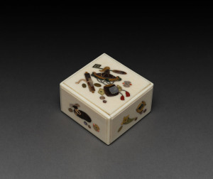 A Shibayama ivory puzzle box decorated with Buddhist symbols, scroll, hat and other objects, Meiji Period, 4cm high, 6.5cm wide, 6cm deep