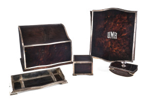 An Edward VIII Sterling silver mounted tortoiseshell five piece Desk Set, comprising a compartmented desk stationary box, a desk compendium with the applied initials "U.M.H.", a pen tray, an inkwell and a rocker blotter. Hallmarked Hardy Brothers, London,