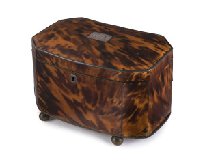 A Georgian brass and pewter inlaid tortoiseshell tea caddy of octagonal section, the hinged domed lid with silver initial plate, enclosing two divided tea compartments with covers, with silver key escutcheon, raised on ball feet. English, early 19th century. PROVENANCE: Christie's Melbourne 15th and 16th of April, 1991.