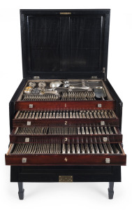 An English sterling silver cutlery set originally for 18 people with servers and accessories. By Frederick Elkington of London, circa 1888, housed in a four tier canteen cabinet with ebonized finish. Missing one spoon and one knife blade. 12kg plus of silver
