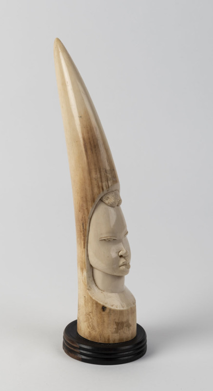 An African carved ivory tusk on ebony stand, early 20th century, ​38cm high overall