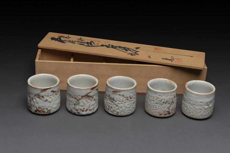 A set of 5 Japanese "shino ware" tea cups in a fitted wooden box.