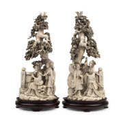 A pair of Chinese carved ivory figures on wooden stands, 19th/20th century, each carved from a solid piece, two character mark to bases, 29cm high overall - 2