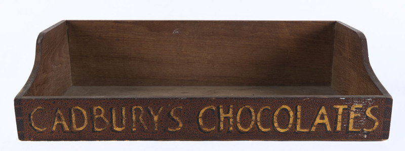 "CADBURY CHOCOLATES" painted across the front of a vendor's wooden tray; lacks the straps from which this would have been suspended around the neck of the vendor; early 20th Century. 61 x 33cm.