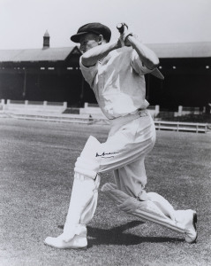 DON BRADMAN, large format black & white photograph of Bradman in his classic "follow-though" stance; signed in black. 50.5 x 40.5cm.