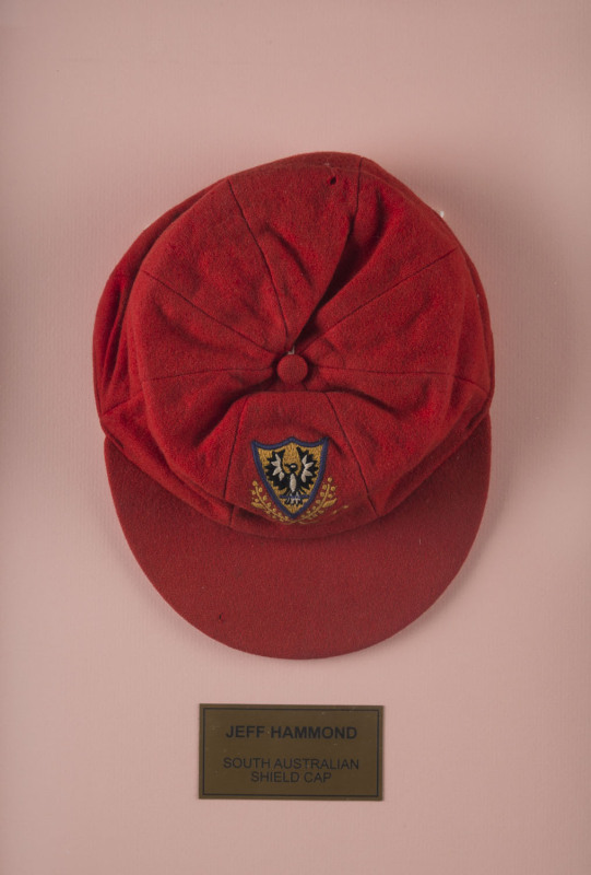 JEFF HAMMOND'S SOUTH AUSTRALIA CRICKET CAP, baggy red with embroidered badge on front, endorsed inside "Ham". Attractively framed. [Hammond played in 5 Tests 1972-73, and played for South Australia between 1969 and 1981]. Provenance: Leski Auctions, Augus