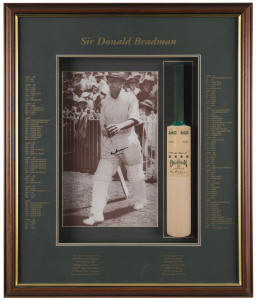 DON BRADMAN framed display featuring a signed photograph of Bradman walking out to bat, together with a mini bat and details of his glorious career. Overall 70 x 57cm.