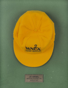 JO ANGEL'S WESTERN AUSTRALIA CAP, yellow wool with the WACA logo embroidered to front and signed beneath the peak by Jo Angel. Attractively framed.A giant fast bowler standing 6 feet 6 inches (198 cm) tall, Angel took 485 first-class wickets, including 44