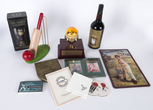 A cricket miscellany including Bradford Exchange plates for Victor Trumper, Greg Chappell, Bill O'Reilly & Don Bradman, a mounted ball signed by Adam Gilchrist & Tony Dodemaide, Jan.1997 at the WACA, a replica Ashes Urn in a presentation box, a bat & ball bookstop, a 1961 Melbourne Test souvenir banner and several other items in a large box.