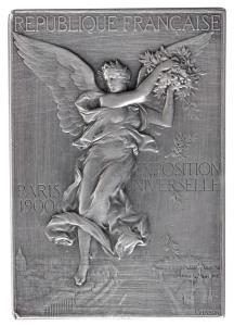 Winner's Plaque in solid silver, for the IXth Shooting Championship of High Schools & Colleges, with "IXME CHAMPIONNAT DE TIR DES LYCEES ET COLLEGES" engraved in the panel at lower right and the name of the recipient, "R. JUGE" at upper right. 55gms, 42 x 60mm. By F. Vernon. The obverse image depicts a winged goddess scattering laurel branches over the Paris Exposition grounds. Reverse: Victorious athlete standing on the podium, the Parthenon in the background. Awarded for the shooting com
