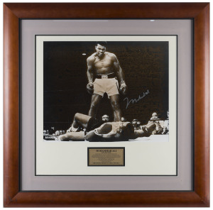 MUHAMMAD ALI "The Greatest" signed photograph, showing Ali standing over Sonny Liston in their 1965 fight; framed and glazed; overall 82 x 81cm. With Superstars & Legends CofA.