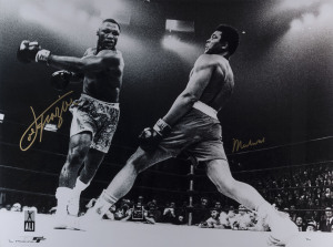 MUHAMMAD ALI & JOE FRAZIER original signatures on a large black & white action photograph from the bout at Madison Square Garden on March 8, 1971. Framed and glazed; overall 110 x 135cm. Accompanied by original Certificate of Authenticity, valuation and background information.