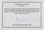 DEVON MALCOLM'S ENGLAND HOME TEST TEAM CAP, navy blue wool with embroidered Crown over three lions on front, with "D.M." to inside label. Very fine condition. Attractively framed. - 5