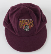 ANDY BICHEL'S QUEENSLAND CRICKET CAP, baggy maroon with embroidered "QUEENSLAND BULLS" badge on front, signed inside by Andy Bichel. [Bichel, a right-arm medium-fast bowler, played 19 Tests 1997-2003 and represented Queensland 98 times between 1992 and 20 - 3