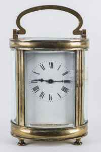 A French oval brass and glass cased carriage clock with Roman numerals, 19th century, 15cm high