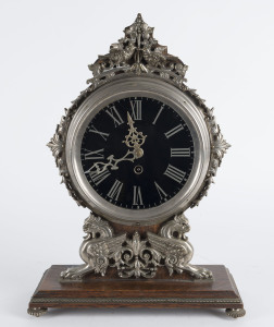 A Continental mantel clock, nickel plate on oak platform base with black glass Roman numeral dial, 19th century 40cm high