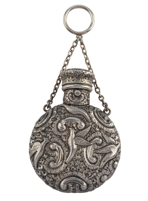 An English sterling silver circular scent bottle chased with exotic birds, scrolls and foliage with attached suspension ring and chain. By Walter Thornhill, London, circa 1887. 8cm high, 71 grams