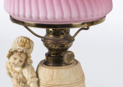 A pair of German figural bisque porcelain kerosene lamps with ruby glass shades, 19th century, 34cm high - 2