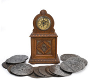 A German musical clock with 4½" disc player accompanied by approximately 45 discs, late 19th century, 32cm high