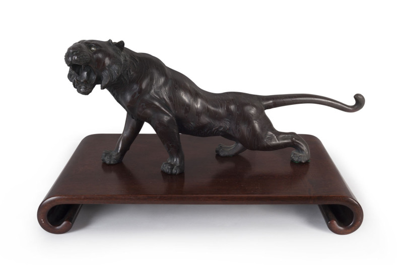 A Japanese bronze tiger statue on wooden stand, Meiji Period, statue length 49cm