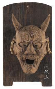 A Japanese mask mounted on board, 19th century, 34cm high overall