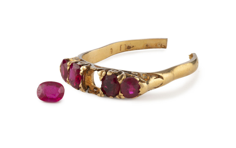 An antique yellow gold ring set with rubies, as is condition, shank has been cut and one ruby loose.
