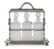 An English silver plated three bottle tantalus with hobnail cut crystal decanter and original key, 19th century, 38cm high