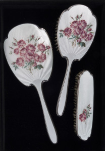 Three pieces of English sterling silver and enamel decorated vanity ware by Elkington & Co. Birmingham, circa 1914, the mirror 29cm high