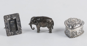 A silver elephant pin cushion, heart shaped box and miniature picture frame, 19th and 20th century, the elephant 5cm long