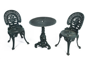 A Coalbrookdale style three piece cast iron garden setting comprising two chairs and a table, late 19th or early 20th century, the table 70cm high, 66cm diameter