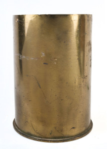 A trench art umbrella stand made from an impressive brass shell with regimental badge attached, shell dated 1915, 46cm high, 34cm diameter