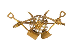 A gold miner's brooch of unusual form with double pick and shovel, sieve, rope and gold nugget, 19th century, housed in a H. Hutton of Ballarat box, 4cm across, 2.8 grams PROVENANCE: Private Collection Ballarat