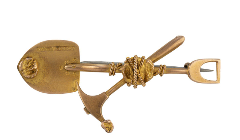 A gold miner's brooch, crossed pick and shovel entwined with rope and gold nugget specimens, stamped "South Africa", ​5.3cm long, 3.7 grams