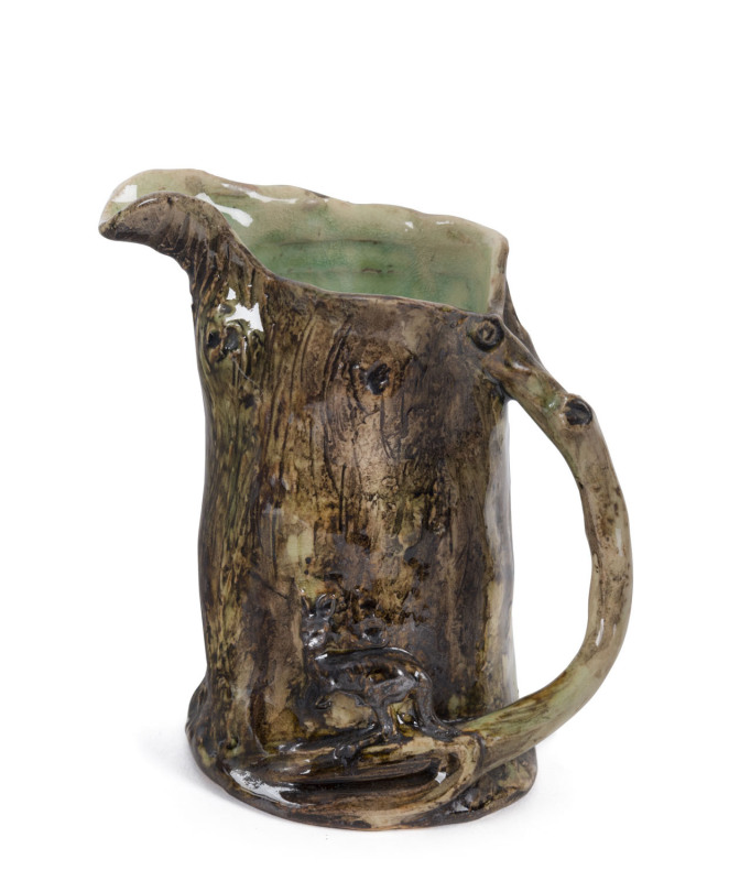 WILLIAM RICKETTS early pottery tree stump jug with applied kangaroo and branch handle, the interior glazed in green, circa 1930s, inscription illegible, ​13cm high