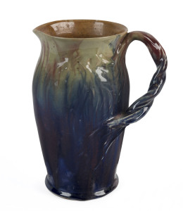 REMUED Pottery jug with windswept tree and branch handle, early colourway, circa 1933, incised "Remued" with no other marks, ​23.5cm high