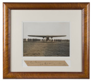 An original albumen photograph of The Southern Cross about to depart from California (22x29cm) mounted, framed & glazed together with a card with the hand-written dedication "To: Billy Beausang, With Best wishes, From "Chas" C.T.P. Ulm, 1928". Overall 48 - 2