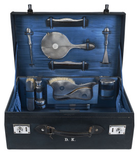 A ladies sterling silver travelling set in silk lined blue leather case, made for ASPREY'S of London, circa 1933, complete and in exceptional condition, each piece monogrammed "D.K.", the case 50cm across