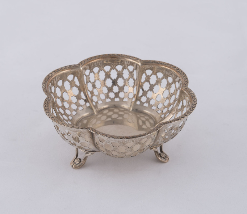 A George V sterling silver pierced fluted bowl raised on three scroll legs, by Snyder & Beddoes, Birmingham, circa 1928, 5cm high, 10cm diameter, 55 grams.